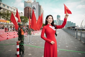 Lý Kim Thảo diện áo dài đỏ rực, thêu chim bồ câu trắng trước ngực